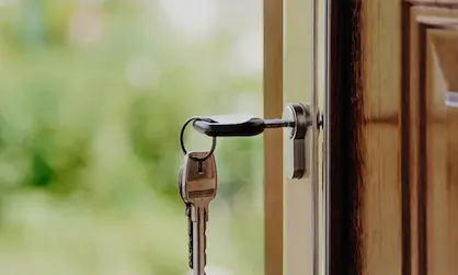uma chave na porta de entrada da casa