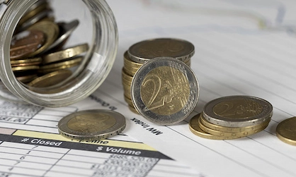 moedas e notas em cima do contrato